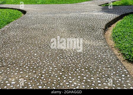 Garden pathway covered with small white stones. Pebble walkway in the garden Stock Photo