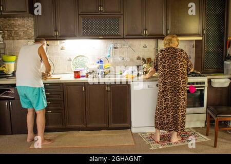 Elderly man and his wife cooking together happily. Strong relationship. Stock Photo