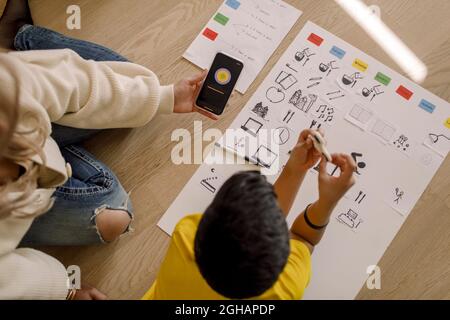Directly above shot of mother showing smart phone to son at home Stock Photo