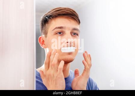 Young Man with Sealed Mouth in the Room at the Home Stock Photo