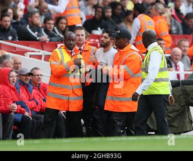 An pitch invader gets escorted off during the pre season match at the Emirates Stadium, London. Picture date 29th July 2017. Picture credit should read: David Klein/Sportimage via PA Images Stock Photo