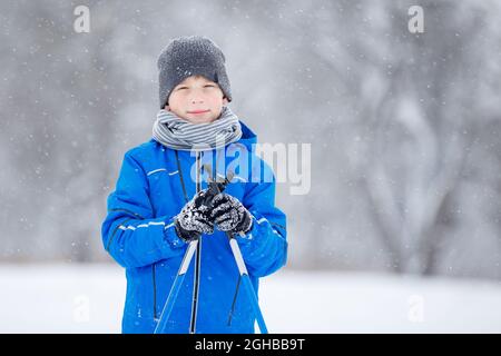 Close up portrait of small boy skiing in the winter park. Stock Photo