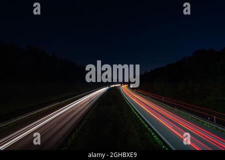 Lighttrails of a traffic motorway from the cars front and headlights, passing fast the point ov view. Stock Photo