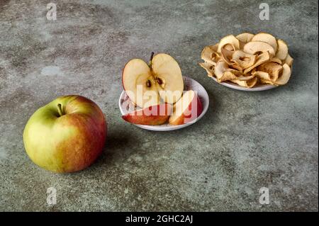 Apples chips, slices and apple fruit on rustic wooden background. Perspective view, selective focus Stock Photo