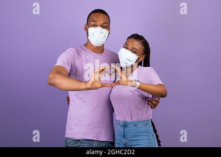 African American couple in mask making heart gesture Stock Photo