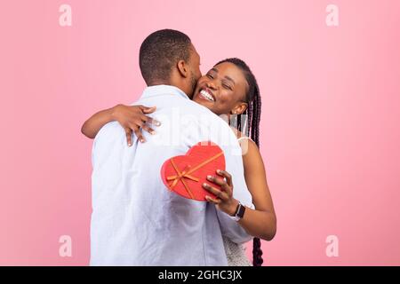 Happy black man making surprise for woman giving box Stock Photo