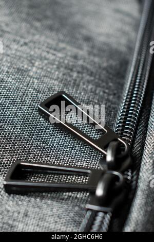 Black metal zipper of a grey polyester backpack Stock Photo