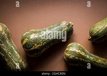 Fresh and green elongated pumpkin on a brown wooden table Stock Photo