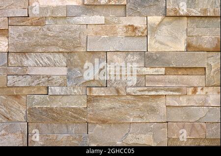 detail of wall of irregular granite or marble brown stones Stock Photo