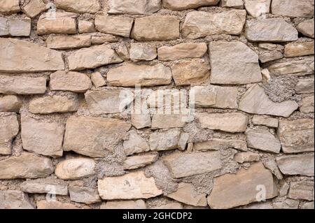 detail of an old irregular stone wall with mortar Stock Photo