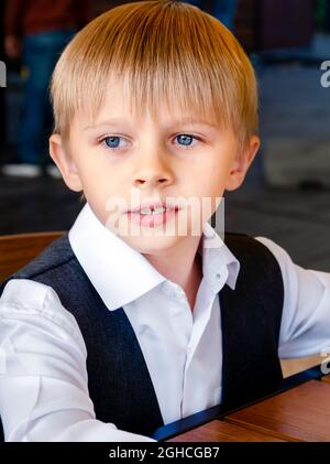 Cute Blond Kid Portrait in the Street Cafe Stock Photo