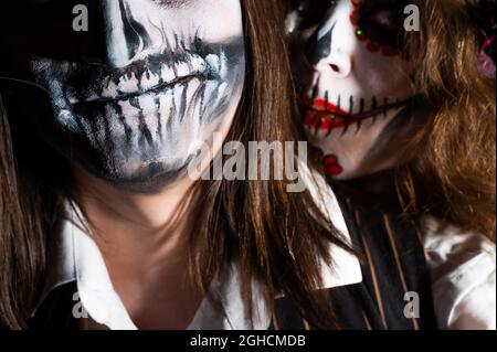 Woman in santa muerte costume and man in skeleton bodypainting for halloween. Stock Photo