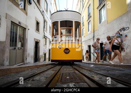 Lisbon, Portugal. 01st Sep, 2021. People are seen next to the Bica funicular, in Lisbon.The Bica funicular was inaugurated in 1892 as a link between 'Largo do Calhariz' Square and 'Rua de Sao Paulo' Street. It worked with the rack rail and water counterbalance system and later with steam. The funicular was then electrified in 1927 and classified as a national monument in 2002. Credit: SOPA Images Limited/Alamy Live News Stock Photo