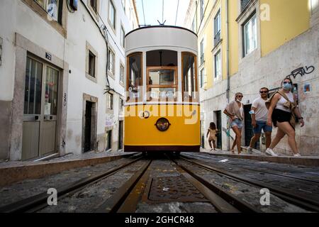 Lisbon, Portugal. 01st Sep, 2021. People are seen next to the Bica funicular, in Lisbon.The Bica funicular was inaugurated in 1892 as a link between 'Largo do Calhariz' Square and 'Rua de Sao Paulo' Street. It worked with the rack rail and water counterbalance system and later with steam. The funicular was then electrified in 1927 and classified as a national monument in 2002. (Photo by Hugo Amaral/SOPA Images/Sipa USA) Credit: Sipa USA/Alamy Live News Stock Photo