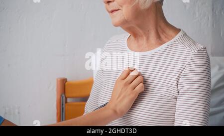 cropped view of nurse examining senior woman in bed Stock Photo