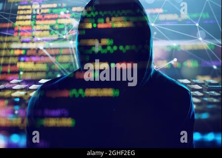 Hidden hacker works in the dark to steal data online Stock Photo