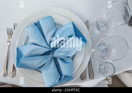 Beautiful table setting on white linen tablecloth. Festive luxury table setting for wedding dinner. Top view. Stock Photo