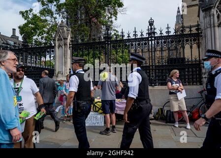 Extinction rebellion activists and police officers walking in line  in front of the Houses of Parliament, Parliament Square, London, UK 06.09.2021 Stock Photo