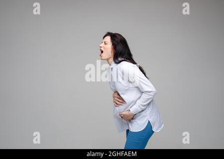 beautiful young pregnant woman screaming beacuse of a strong stomach ache Stock Photo