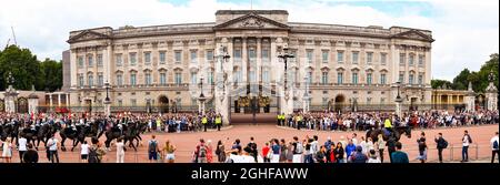London, England - August 2021: Panoramic view of mounted cavalry in ceremonial dress passing Buckingham Palace after Changing of the Guard Stock Photo
