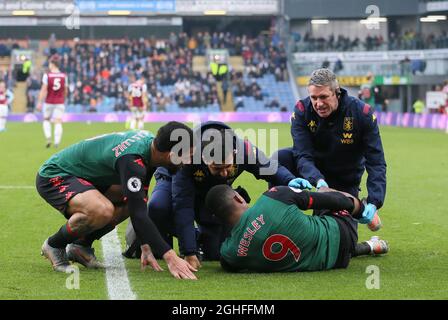 Wesley of Aston Villa stays down injured after a tackle by Ben Mee