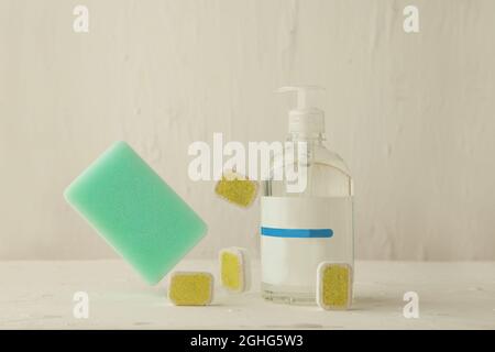 Dishwasher tabs for cleaning with sponge. washing tablets and liquid in levitation Stock Photo