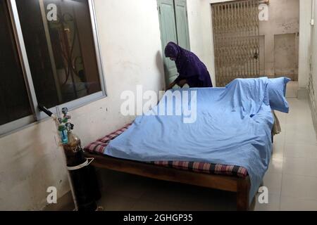 A woman prepares the bed  inside of an  isolation area, as preventive measure in case a student falls sick, in Agrani School. After more that  one  year of take online class due the  coronavirus lockdown by safety  restrictions, schools are ready to receive the children, in the classrooms as the government have allowed  that students, will attend classes from the next week. On September 6, 2021in Dhaka, Bangladesh. (Photo by Habibur Rahman / Eyepix Group) Stock Photo
