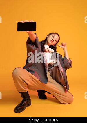 Studio shot of fashionable young woman holding a smart phone Stock Photo