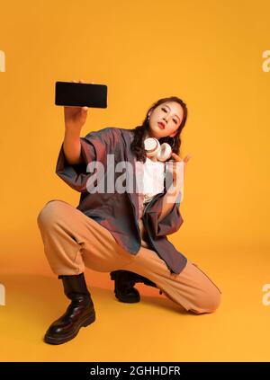 Studio shot of fashionable young woman holding a smart phone Stock Photo