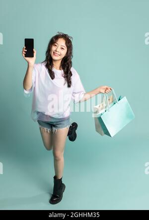 Studio shot of cute young woman shopping Stock Photo