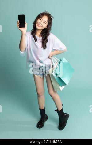 Studio shot of cute young woman shopping Stock Photo