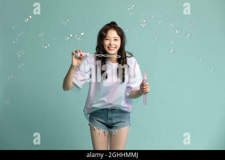 Studio shot of cute young woman blowing bubbles Stock Photo