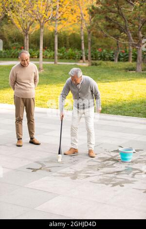 Senior man practicing calligraphy in the park Stock Photo