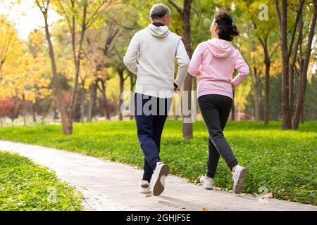 Happy senior couple running in the park Stock Photo