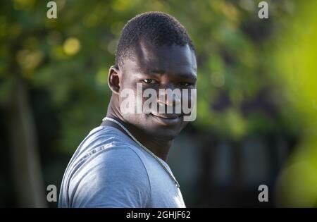 Portrait of smiling and satisfied young african man standing in park Stock Photo