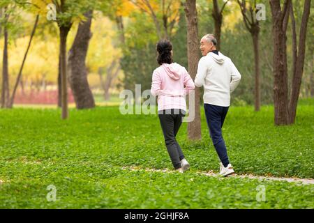 Happy senior couple running in the park Stock Photo