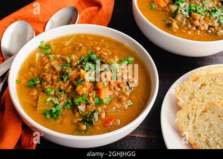 Moroccan Sweet Potato Lentil Soup Garnished with Fresh Herbs: Vegetable and lentil soup with fresh herbs served with fresh bread Stock Photo
