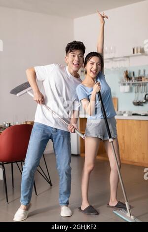 Cheerful young couple doing housework Stock Photo