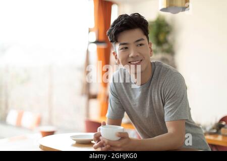 Cheerful young man drinking coffee Stock Photo