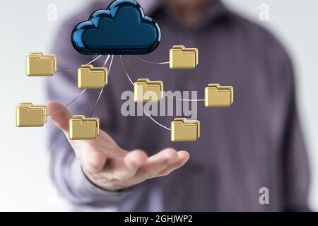 Hand holding a cloud icon with folders - the concept of cloud computing Stock Photo