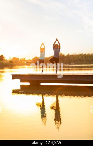 Happy mature couple doing yoga in park Stock Photo
