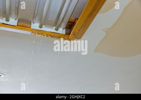 Broken water pipe causes water dripping from ceiling Stock Photo