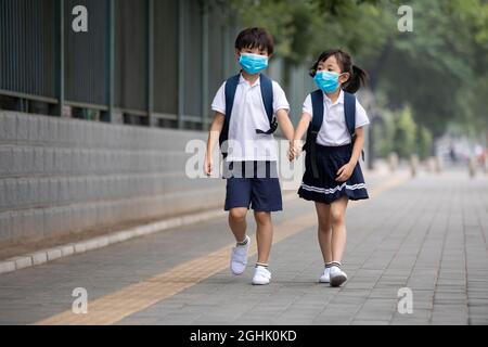Two pupils wearing surgical masks to go to school Stock Photo