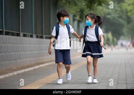 Two pupils wearing surgical masks to go to school Stock Photo