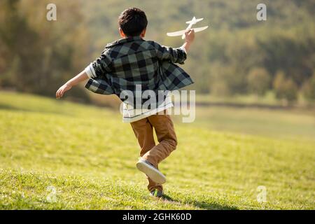 Happy boy playing on meadow Stock Photo