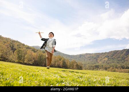 Happy boy playing on meadow Stock Photo