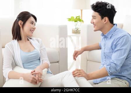 Happy young couple relaxing in living room Stock Photo