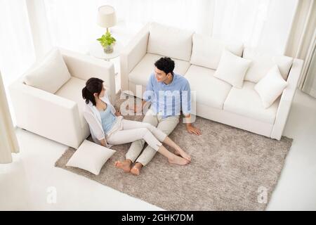 Happy young couple relaxing in living room Stock Photo