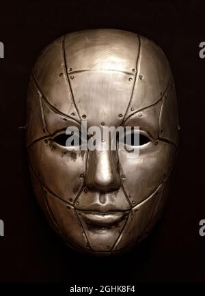 Bronze Robot Face Mask Isolated Against Brown Background Stock Photo