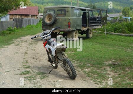 SUV UAZ-452 and motorcycle in the village Stock Photo